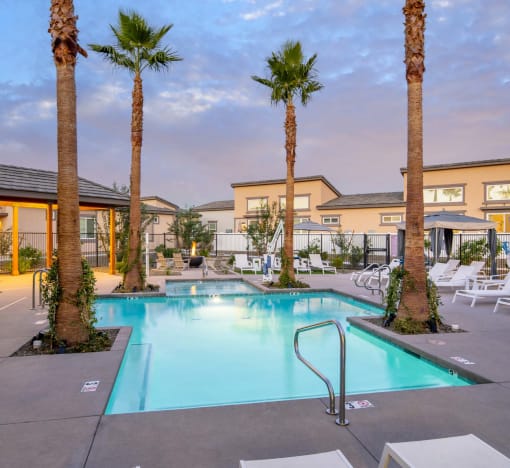 a swimming pool with palm trees and chairs around it at Grandstone at Sunrise, Peoria, AZ, 85383